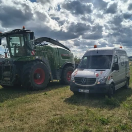 Traktor und Servicefahrzeug auf Feld